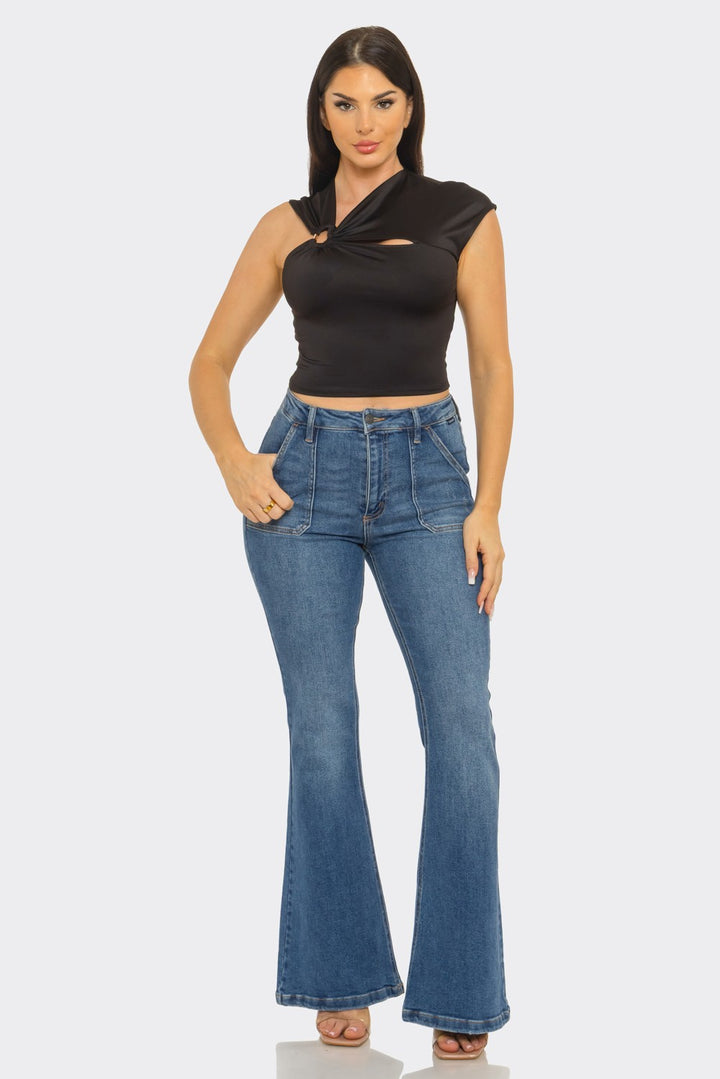 Twisted cutout ring crop top in black — front view with flare jeans
